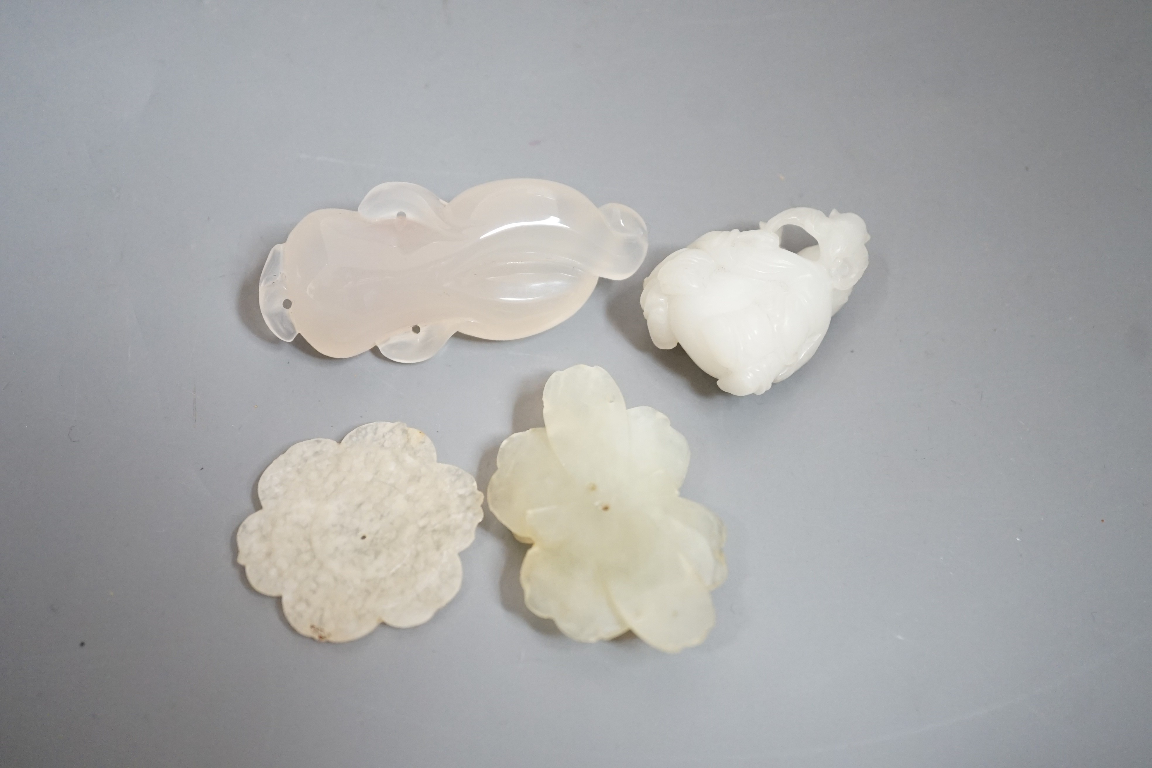 Two Chinese jade flower head carvings, Ming dynasty, a white Jade group of two boys and a monkey and an agate carving (4)